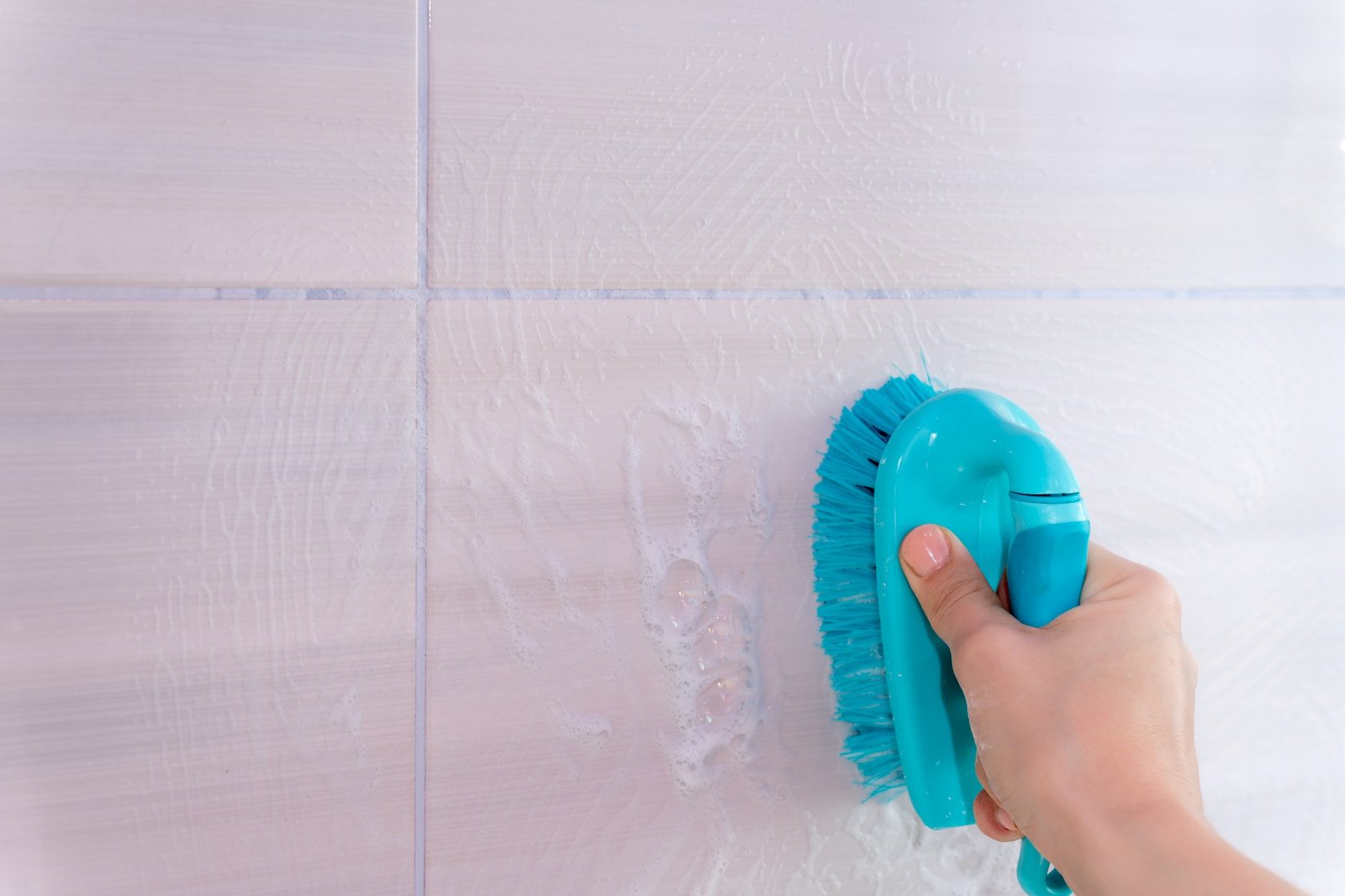 Verfärbte Fliesenfugen in der Dusche werden gereinigt